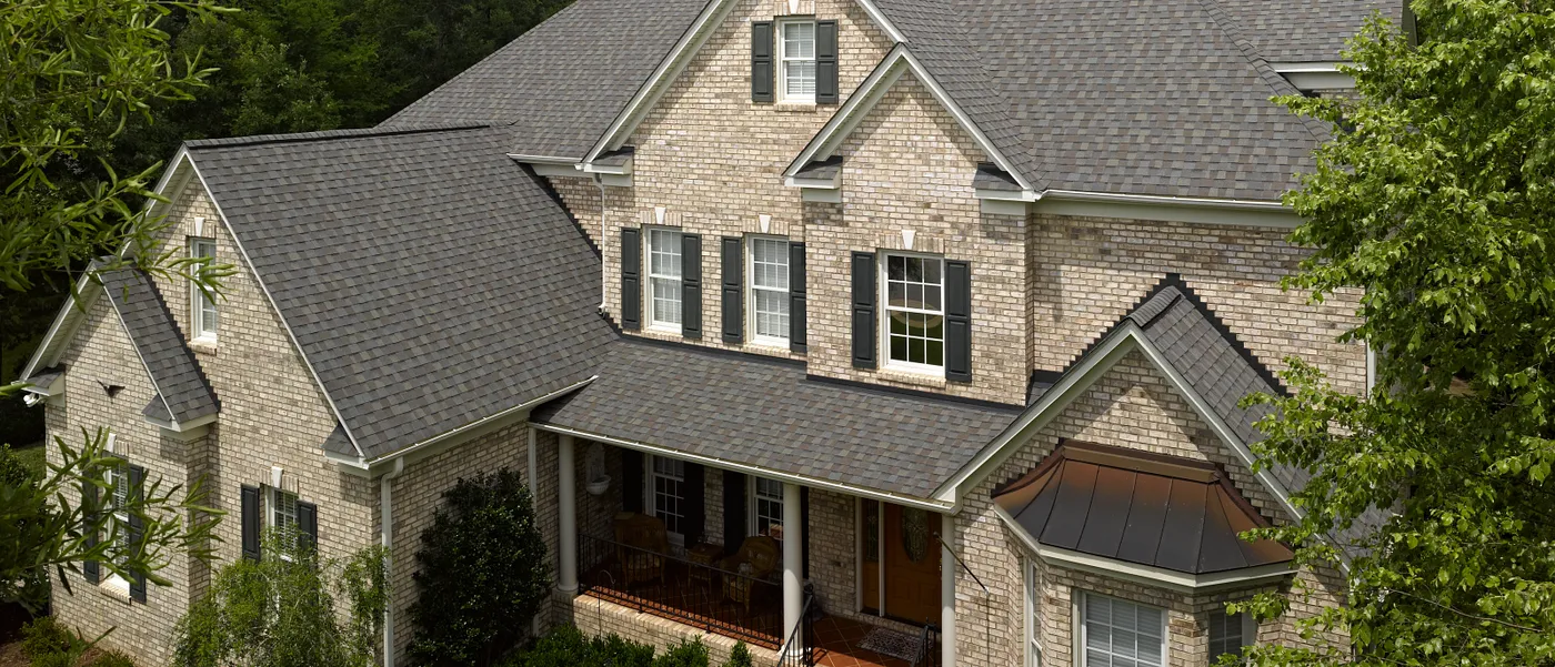 CertainTeed Landmark architectural shingles in the Driftwood color on a light brick home, from CertainTeed's official Landmark product page