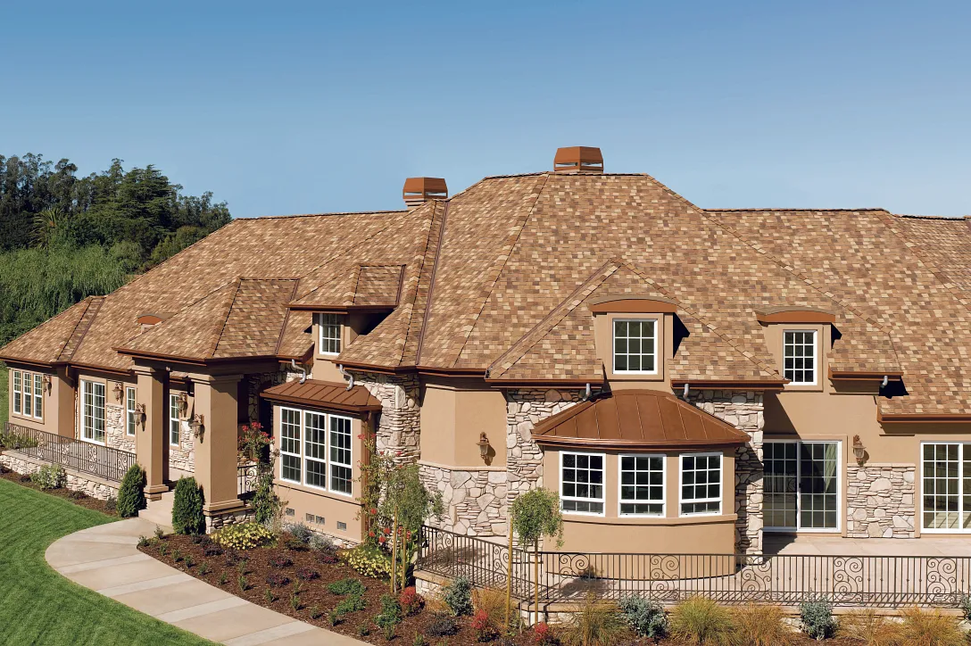 CertainTeed Landmark TL triple laminate shingles in Chestnut on a tan house, from CertainTeed's official Landmark product page