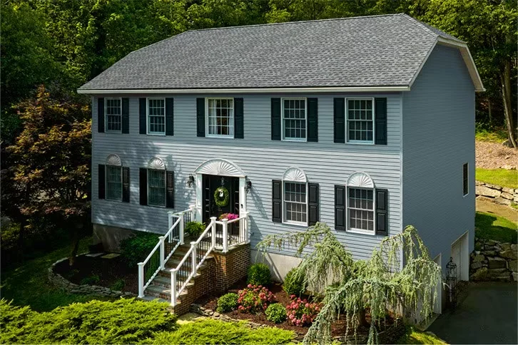 GAF Timberline HDZ architectural shingles in Pewter Gray on a two-story blue clapboard home, from GAF's official Timberline HDZ product page